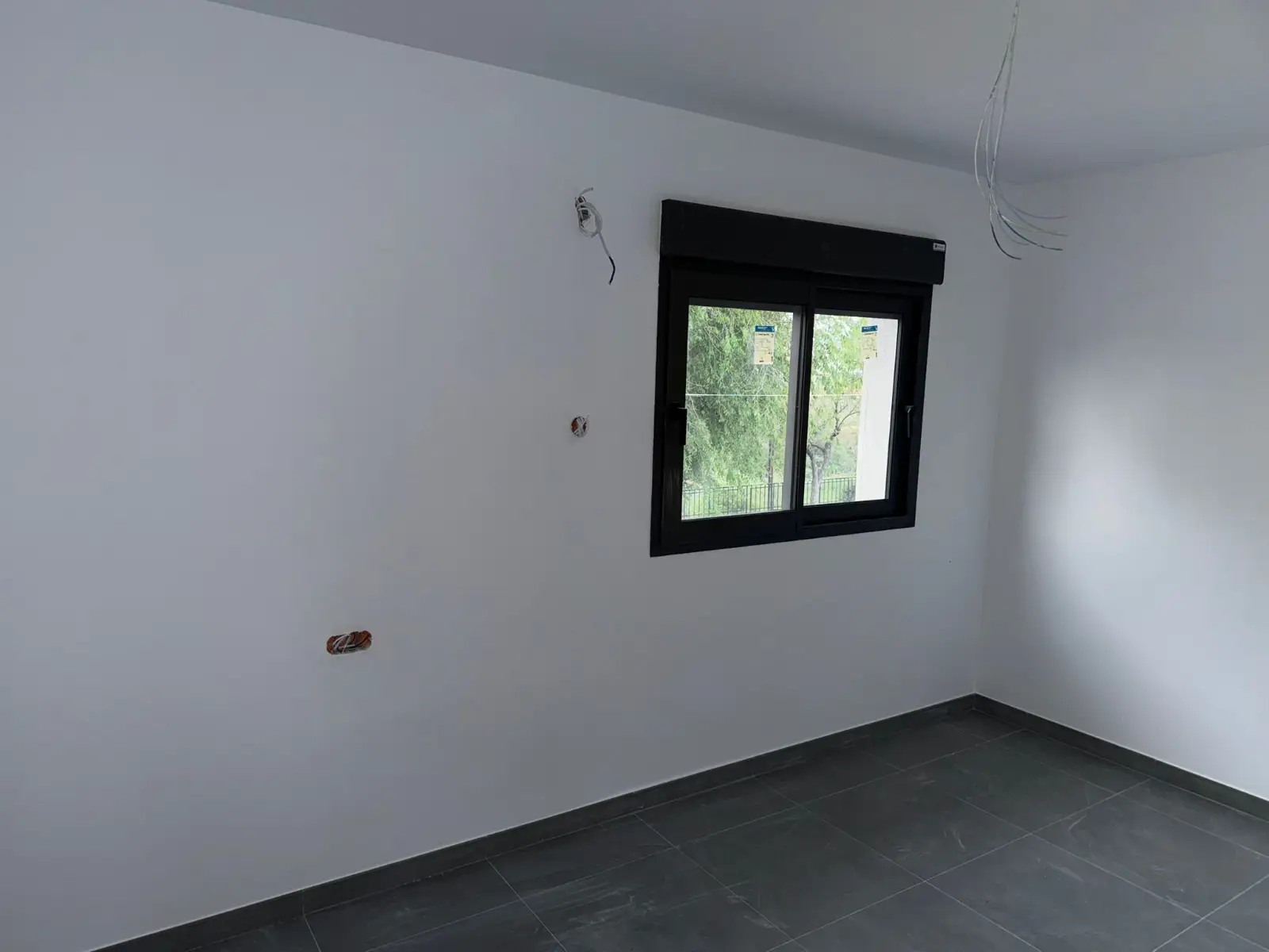 Reforma de vivienda con suelo porcelánico gris y carpintería de ventana negra en Valencia